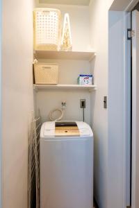 a washer and dryer in a laundry room with shelves at Nishihan in Kyoto +22 photos