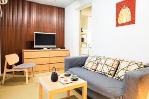 a living room with a couch and a tv at Nishihan in Kyoto