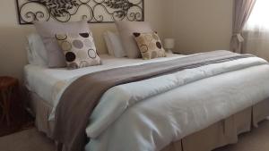 a bed with white sheets and pillows on it at Amalie Cottage Waikerie Unit 1 in Waikerie
