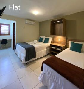 a hotel room with two beds and a window at Muriú Beach Flat in Muriú