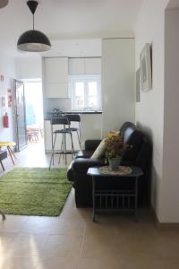 a living room with a couch and a table at Casinha da Andorinha - Ericeira in Ericeira