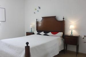 a bedroom with a large bed with two night stands at Casinha da Andorinha - Ericeira in Ericeira