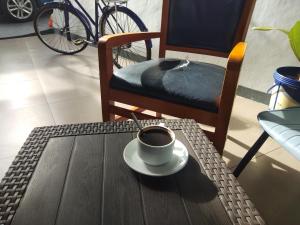 una taza de café en una mesa con una silla en Bukittinggi Homestay, en Bukittinggi