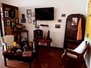 een woonkamer met een flatscreen-tv aan de muur bij Casa no Centro Histórico de Pirenópolis in Pirenópolis