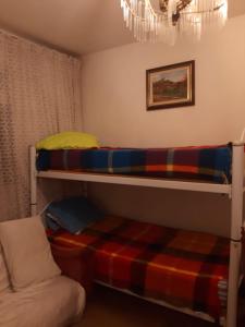 2 stapelbedden in een kamer met een bank bij Apartamento para Temporada no Gonzaga in Santos