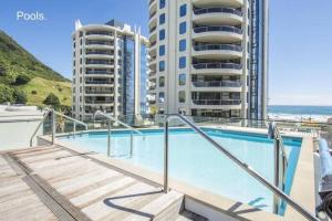 a swimming pool with two tall buildings in the background at ELEVEN APARTMENT in Tauranga