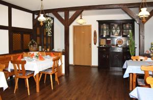 eine Küche und ein Esszimmer mit einem Tisch und Stühlen in der Unterkunft Pension Rotsteinblick in Sohland am Rotstein
