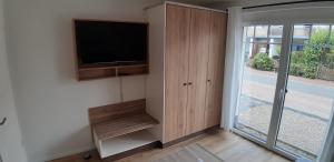 a living room with a tv and a sliding glass door at Deichresidenz Büsum in Büsum