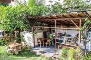 una pérgola con una mesa y una mesa y sillas en Villa Ricca Eco Lodge, en Uluwatu
