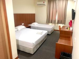 a hotel room with two beds and a desk at Grand Hotel 2 in Keningau