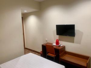 a room with a bed and a desk with a television at Grand Hotel 2 in Keningau