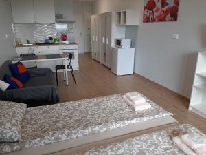 a living room with a bed and a kitchen at Apartment Cherry Bratislava & Free Parking in Bratislava