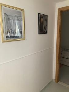a picture on a white wall with a picture on it at Old pearl apartment in Stari Grad