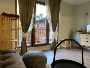 a living room with a couch and large windows at Estudio reformado Vall d'Incles Grandvalira, 4 pers, max 2 adultos y 2 niños menores 12 años in Canillo