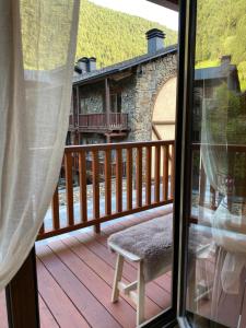 a view of a deck from a window with a chair at Estudio reformado Vall d'Incles Grandvalira, 4 pers, max 2 adultos y 2 niños menores 12 años in Canillo