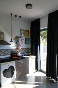 uma cozinha com armários brancos e uma grande janela em Pefkos Eye em Pefki Rhodes