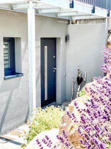 een huis met een blauwe deur en paarse bloemen bij Ferienwohnung Bodensee Nenzingen Hegau in Orsingen-Nenzingen