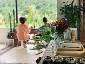 two people sitting at a table looking out a window at Pai Vieng Fah Resort in Pai