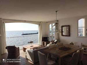 a living room with a table and a view of the ocean at Port rive gauche Oyat in Marseillan +10 photos