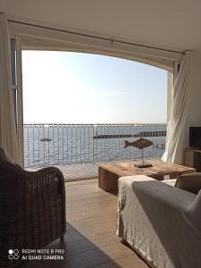 a living room with a large view of the ocean at Port rive gauche Oyat in Marseillan