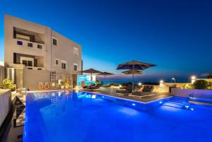 a swimming pool in front of a building at night at Talos Luxury Suites in Kounoupidhianá