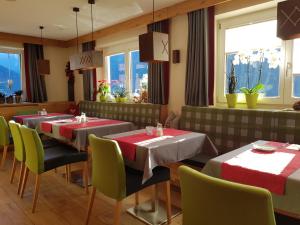 un restaurante con 2 mesas, sillas y ventanas en Hotel Appart Peter, en Sölden