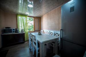 Una cocina con mesa y sillas y un refrigerador. en Family Apartments "IGWT", en Tiflis
