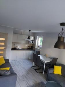 a kitchen and a living room with a table and chairs at Apartament Snow White in Karpacz