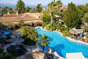 an aerial view of a resort pool with palm trees at Achtis Hotel in Afitos