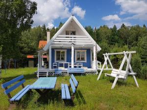 een klein blauw huis met een picknicktafel en twee stoelen bij Błękitny Domek - Tleń - Bory Tucholskie in Tleń