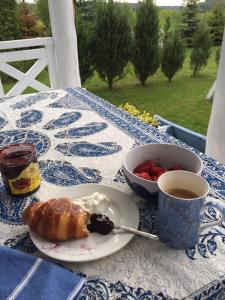 a table with a plate of food and a cup of coffee at Błękitny Domek - Tleń - Bory Tucholskie in Tleń