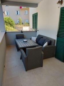a patio with a table and chairs and a couch at Dalmatino - apartment 6 in Sutivan