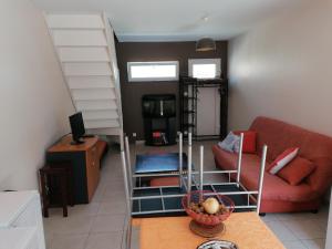 a living room with a red couch and a staircase at Le sacré cœur bis -duplex 5pl in Le Havre