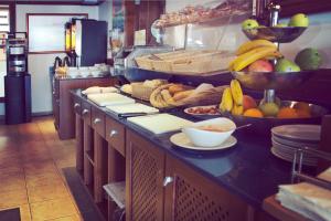 - une cuisine avec un bouquet de fruits sur un comptoir dans l'établissement Hotel Bahía, à La Savina