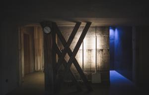 une chambre sombre avec une horloge sur un mur dans l'établissement Niedermairhof, à Brunico