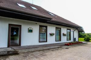a white building with windows and flowers on it at Vila Romnesa in Ignalina
