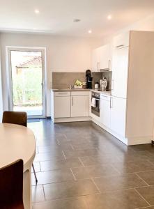 a kitchen with white cabinets and a tile floor at Ferienwohnung Bodensee Nenzingen Hegau in Orsingen-Nenzingen