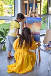 Une petite fille en robe jaune peint une photo dans l'établissement Corner House, à Odessa