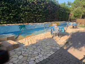 un patio con tavolo e sedie in un cortile posteriore di Azul - privacy tranquillità natura e mare a Rosolina Mare