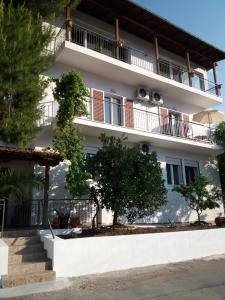 ein Gebäude mit Balkonen und Bäumen davor in der Unterkunft Koukounari Studios in Neos Marmaras