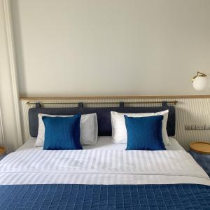 a large bed with blue and white pillows at BLU 395 Ari-Saphan Khwai in Bangkok
