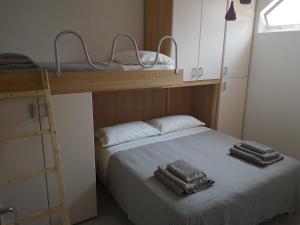 Il Tetto Verde في فوساتشيزيا: غرفة نوم مع سرير بطابقين مع منشفتين