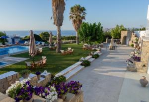 un complejo con piscina, palmeras y flores en Fragoulis Village, en Parasporos