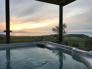 a plunge pool with a plant and the sunset at Carrick Hills Cosy Croft STL SA-00137-F in Dunure