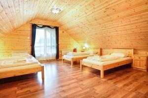a room with three beds in a wooden cabin at Family Panzio es Apartman Hazak in Lipót
