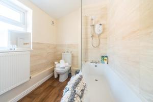 uma casa de banho com uma banheira branca e um WC. em 3 Bedroom-5 Beds Newland Ave King's Palace Leisure-Contractor-Heart of Hull Amenities em Hull