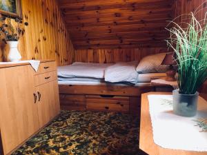 a room with a bed in a wooden cabin at Zielona Sielanka in Orzyny