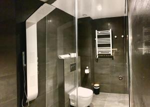 a bathroom with a toilet and a glass shower at Mamma Mia Hotel Boutique - Only Adults in Tossa de Mar