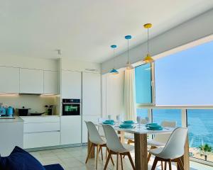 a kitchen and dining room with a table and chairs at Seafront New Apartment Boutique in Lloret de Mar