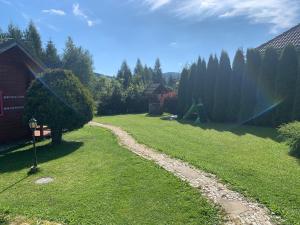 een tuin met een pad in het gras bij Trzy Domki Wysowa in Wysowa-Zdrój